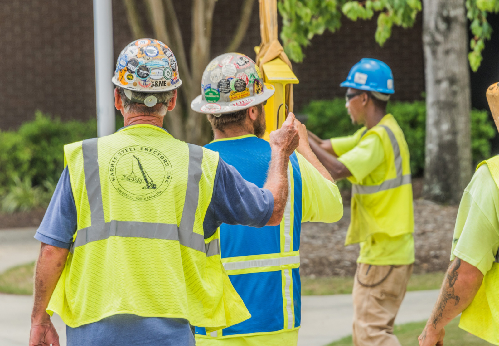 Blum Construction workers attaching a steel beam to a crane