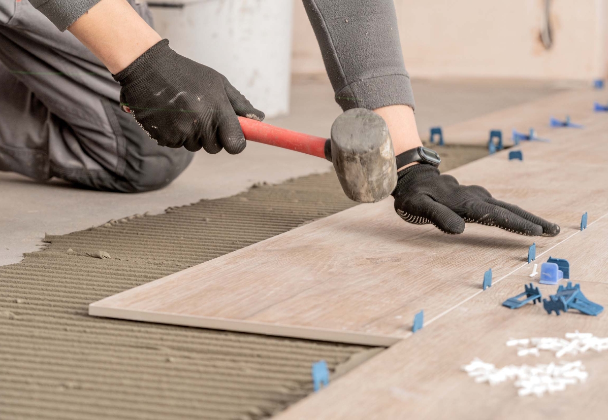 Blum Construction worker installing ceramic floor tile