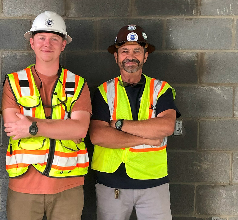 Blum Construction intern posing next to mentor