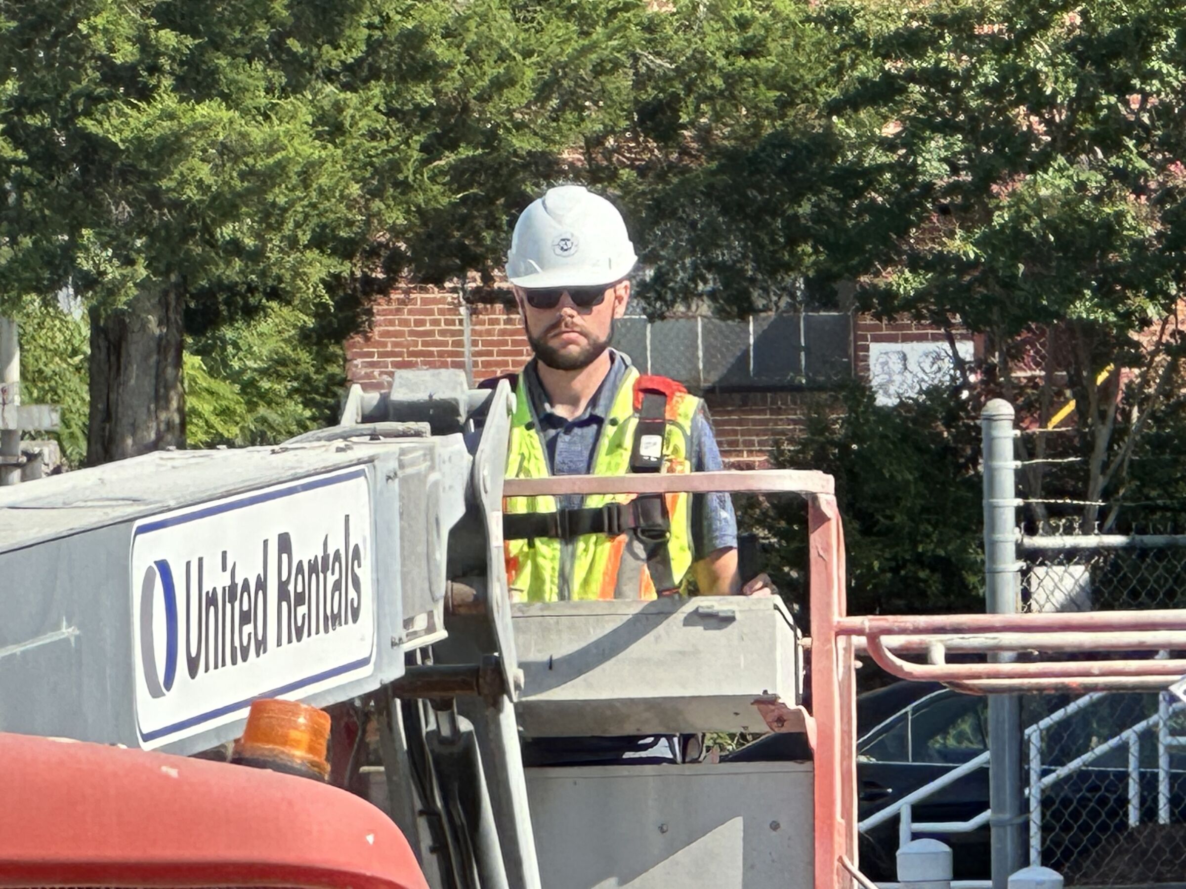 Blum construction worker with a hard hat operating large equipment.