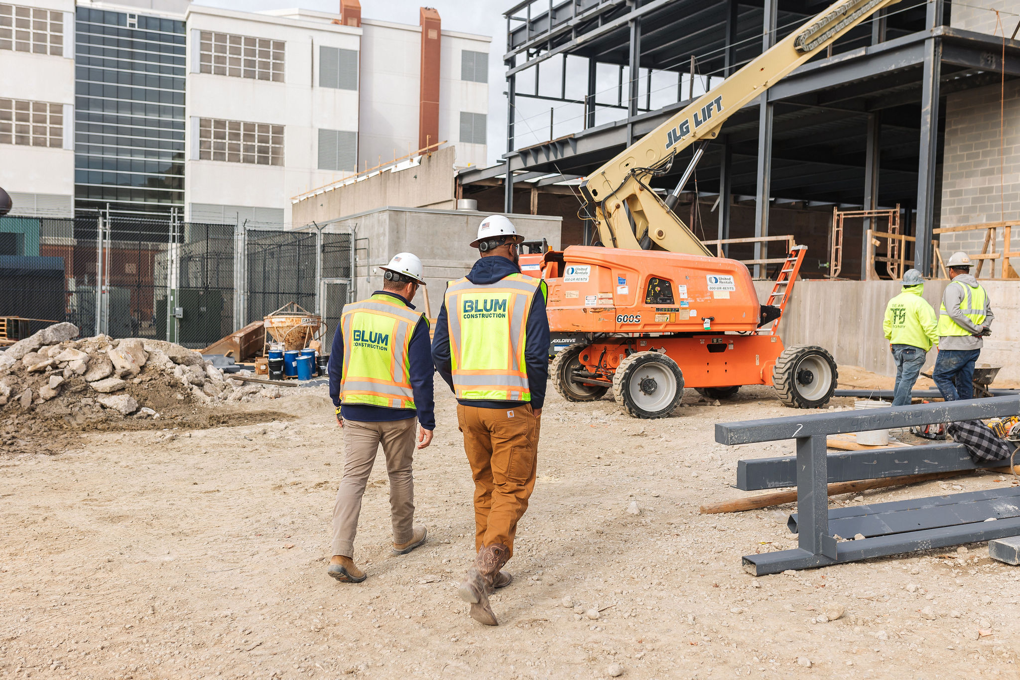 Blum construction workers in hard hats on a construction site.